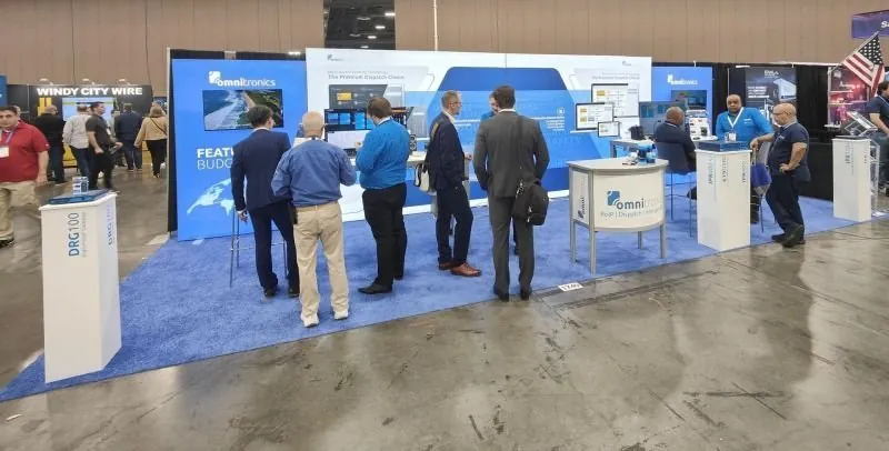 The Omnitronics trade-show booth at a North American industry expo &mdash; the Dispatch Cloud platform on display, customers in conversation.